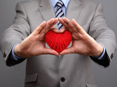 Man holding a red woolen heart concept for valentine's day, business customer care, charity, social and corporate responsibility
