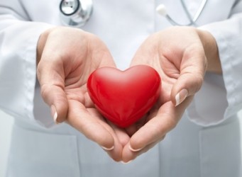 Female doctor with the stethoscope holding heart