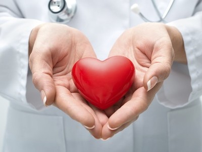 Female doctor with the stethoscope holding heart