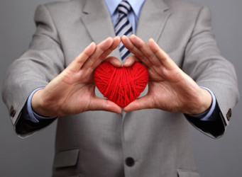 Man holding a red woolen heart concept for valentine's day, business customer care, charity, social and corporate responsibility