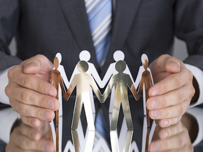 Businessman protecting paper people