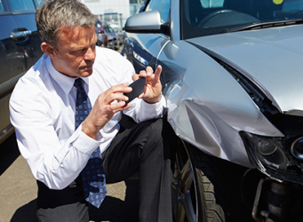 A Man Taking a Photo of His Smashed Bumper for His Car Insurance Company